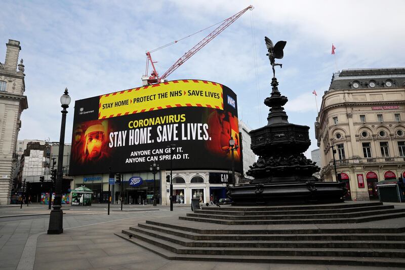 A video screen displays a message urging people to stay home in a nearly deserted Piccadilly Circus in London. AP Photo