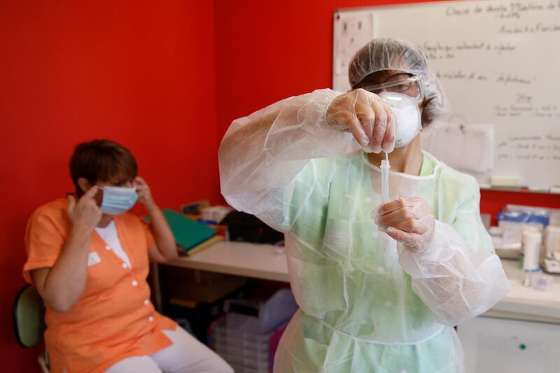 A nurse works on an antigen speed test after performing it on a woman in a nursing home in Ammerschwihr, eastern France. AP Photo