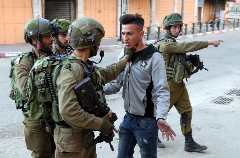 Israeli army soldiers arrest a Palestinian following scuffles during clashes with Palestinian stone-throwers in the West Bank city of Hebron. Clashes erupted after the weekly Friday prayers.  EPA