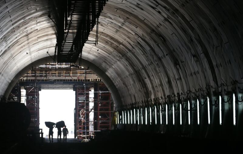 Labourers walk near the entrance to one of the new tunnels. EPA