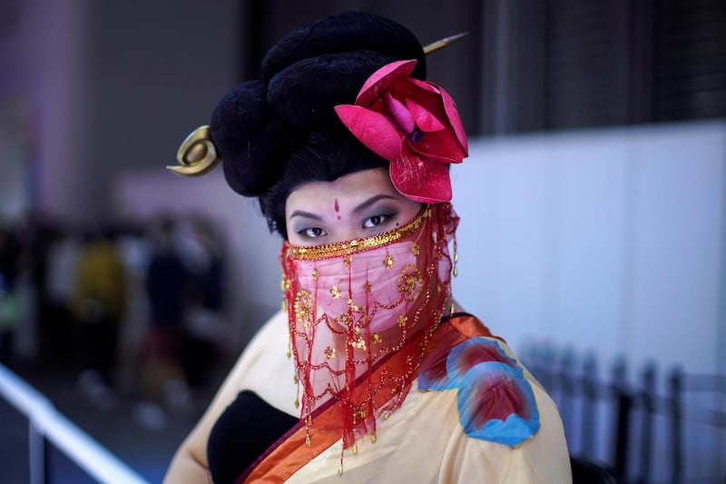 A cosplayer wearing a face mask poses for a picture at the China Digital Entertainment Expo and Conference (ChinaJoy) in Shanghai, China. Reuters