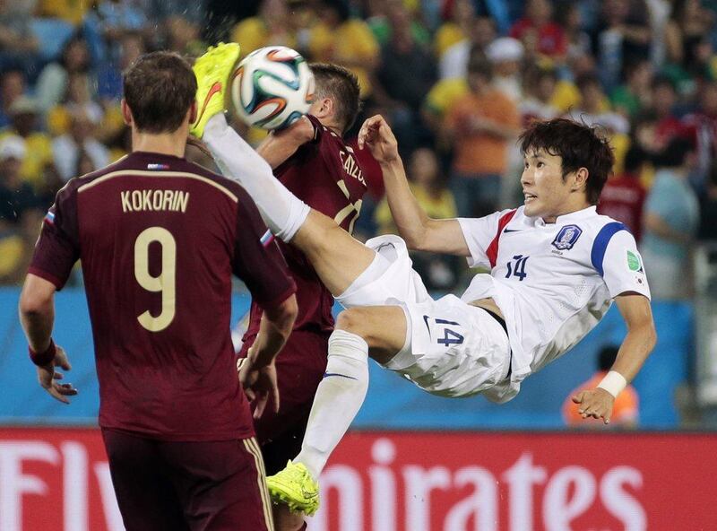 South Korea's Hong Jeong-ho, right, scissor kicks at the ball between Russia's Viktor Fayzulin and Alexander Kokorin during their 1-1 draw on Tuesday at the 2014 World Cup in Cuiaba, Brazil. Ivan Sekretarev / AP
