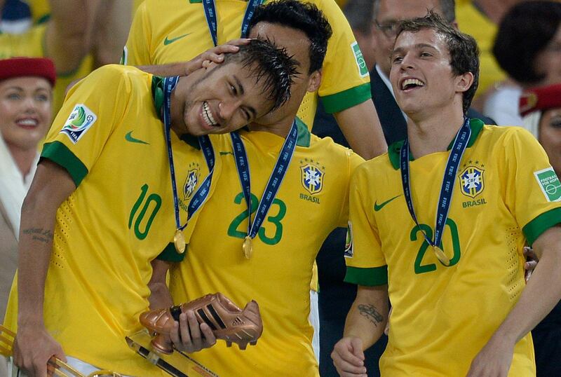 Brazil's forwards Neymar (L), Jadson (C) and Bernard celebrate after winning the FIFA Confederations Cup Brazil 2013, at the Maracana Stadium in Rio de Janeiro on June 30, 2013. Brazil won the title after defeating Spain 3-0 in the final of the football tournament. AFP PHOTO / LLUIS GENE
 *** Local Caption ***  464094-01-08.jpg