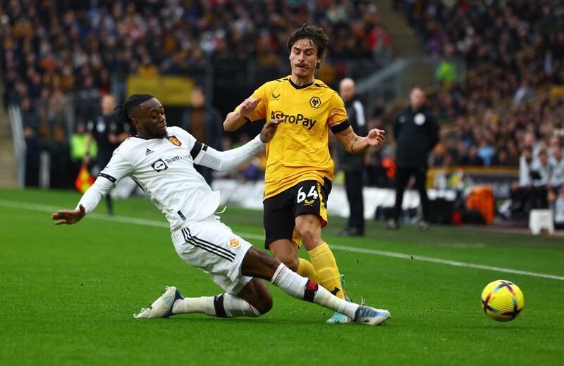 Wolves' Hugo Bueno is tackled by United full-back Aaron Wan-Bissaka. Reuters