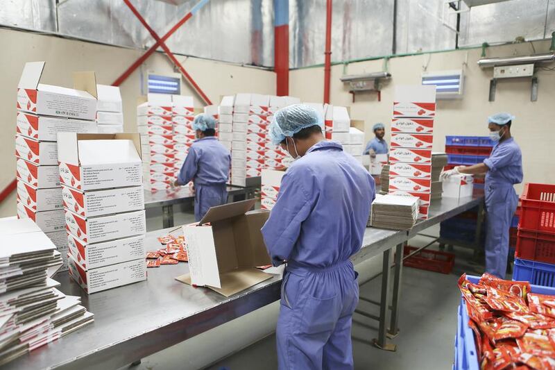 Workers prepare shipments of tomato paste packets at the Chilly Willy manufacturing facility in Dubai, June 3, 2015.