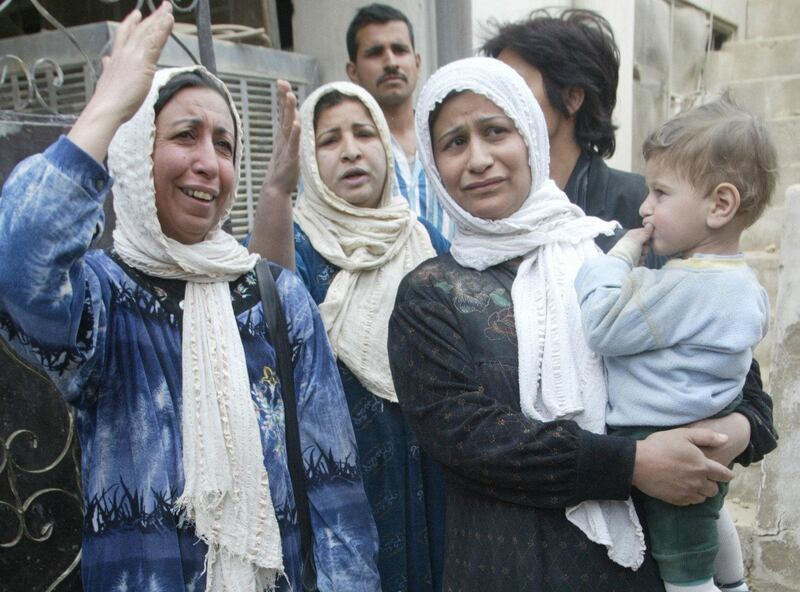 Women grieve outside a house destroyed in US bombing in Baghdad's al-Aazamiya neighborhood 24 March 2003. Five members of the same family were killed and at least 28 others wounded when a missile fired by allied warplanes hit houses in the densely populated area in the Iraqi capital, according to residents. AFP PHOTO/Ramzi HAIDAR (Photo by RAMZI HAIDAR / AFP)