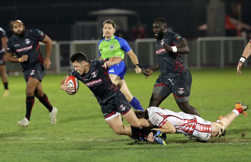 An Abu Dhabi Harlequins player tackles a Dubai Exiles player during the UAE Premiership final.