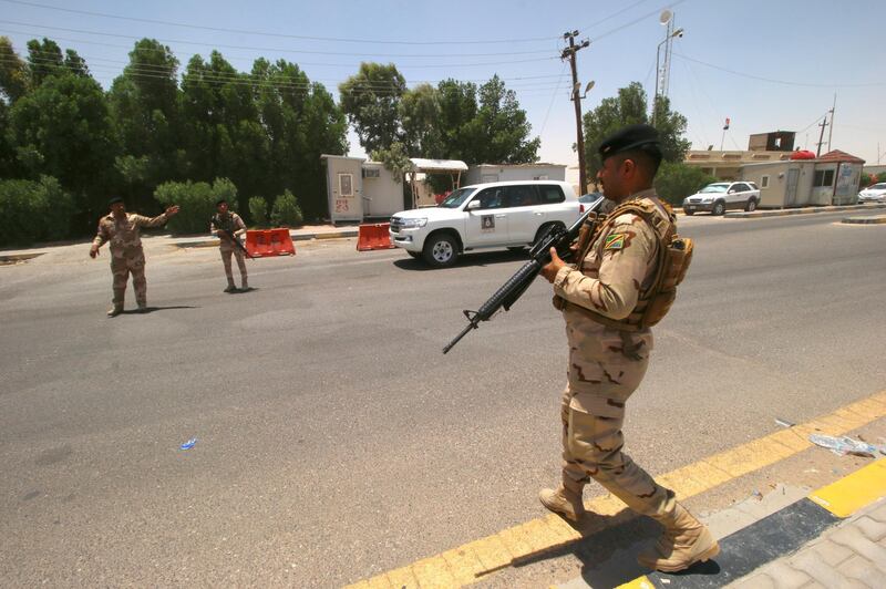 Soldiers stay guard at the entry of Zubair oilfield. Reuters