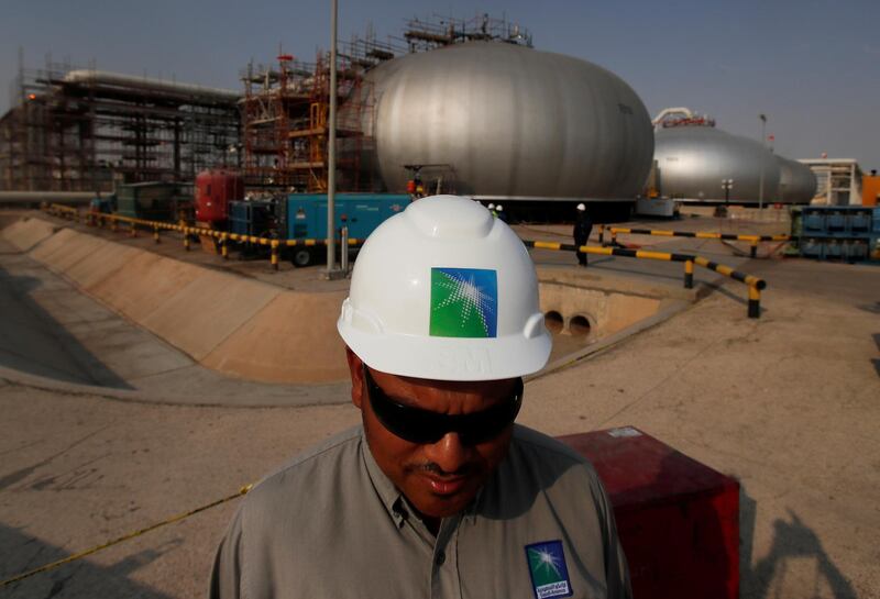 FILE PHOTO: An employee in a branded helmet is pictured at Saudi Aramco oil facility in Abqaiq, Saudi Arabia October 12, 2019. REUTERS/Maxim Shemetov/File Photo