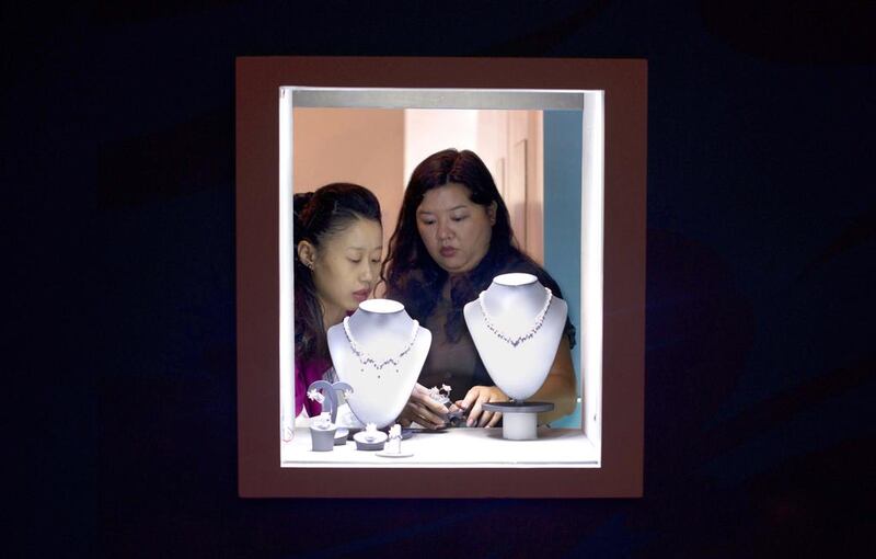 Two vendors adjust a display of jewels at the Hong Kong Jewellery and Gem Fair. Alex Ogle / AFP