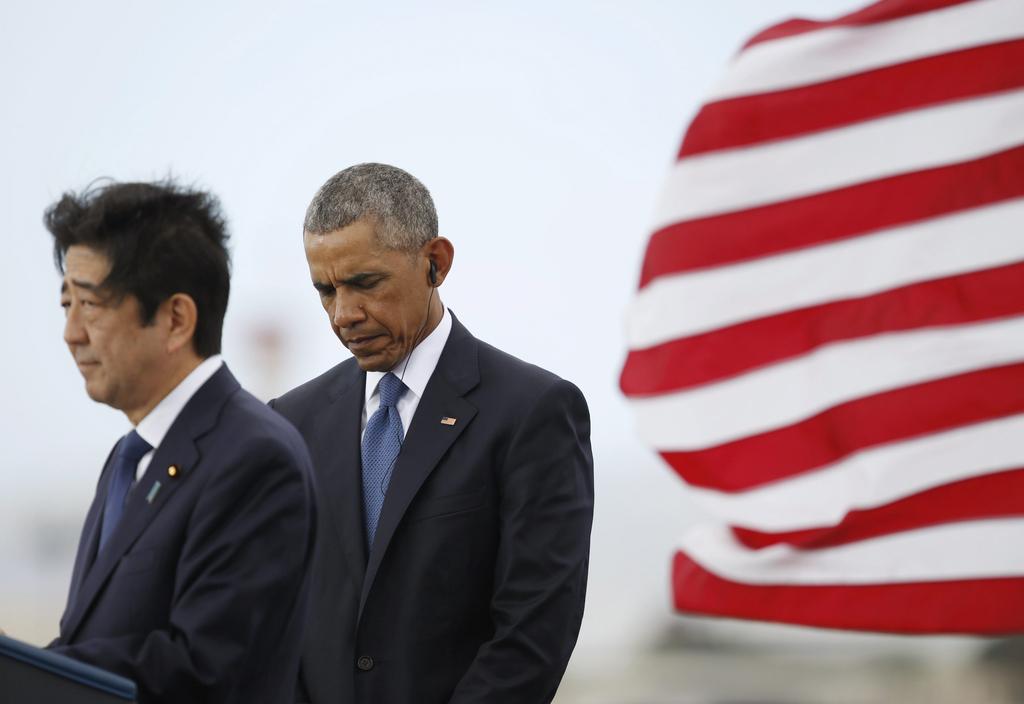 US president Barack Obama stands behind Japanese prime minister Shinzo Abe, left, as he speaks on Kilo Pier overlooking the USS Arizona Memorial, part of the Second World War Valor in the Pacific National Monument, at Joint Base Pearl Harbor-Hickam, Hawaii. Carolyn Kaster / AP