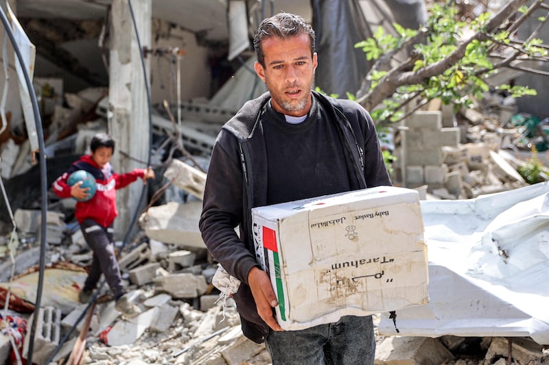 A man collects this aid package from the UAE-Egypt airdrop
