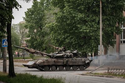 A Ukrainian main battle tank drives on a street during nearby mortar shelling in Severodonetsk, eastern Ukraine, on May 18, 2022, on the 84th day of the Russian invasion of Ukraine. AFP