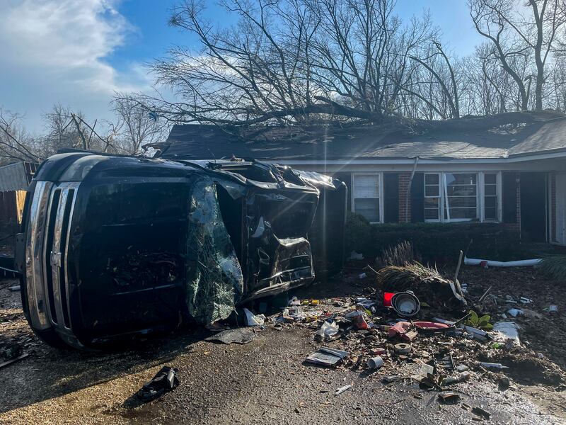 A damaged vehicle rests on its side in front of a home in Selma. AP