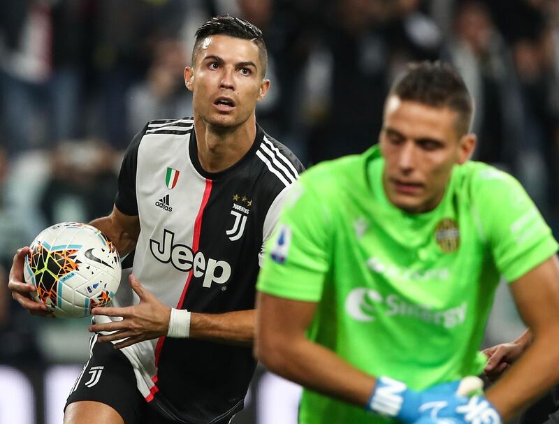 Juventus' Portuguese forward Cristiano Ronaldo grabs the ball after scoring a penalty against Verona's Italian goalkeeper Marco Silvestri. The match fined 2-1 to Juventus. AFP
