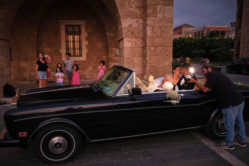 A couple they sit in a classic car after their wedding in Batroun.