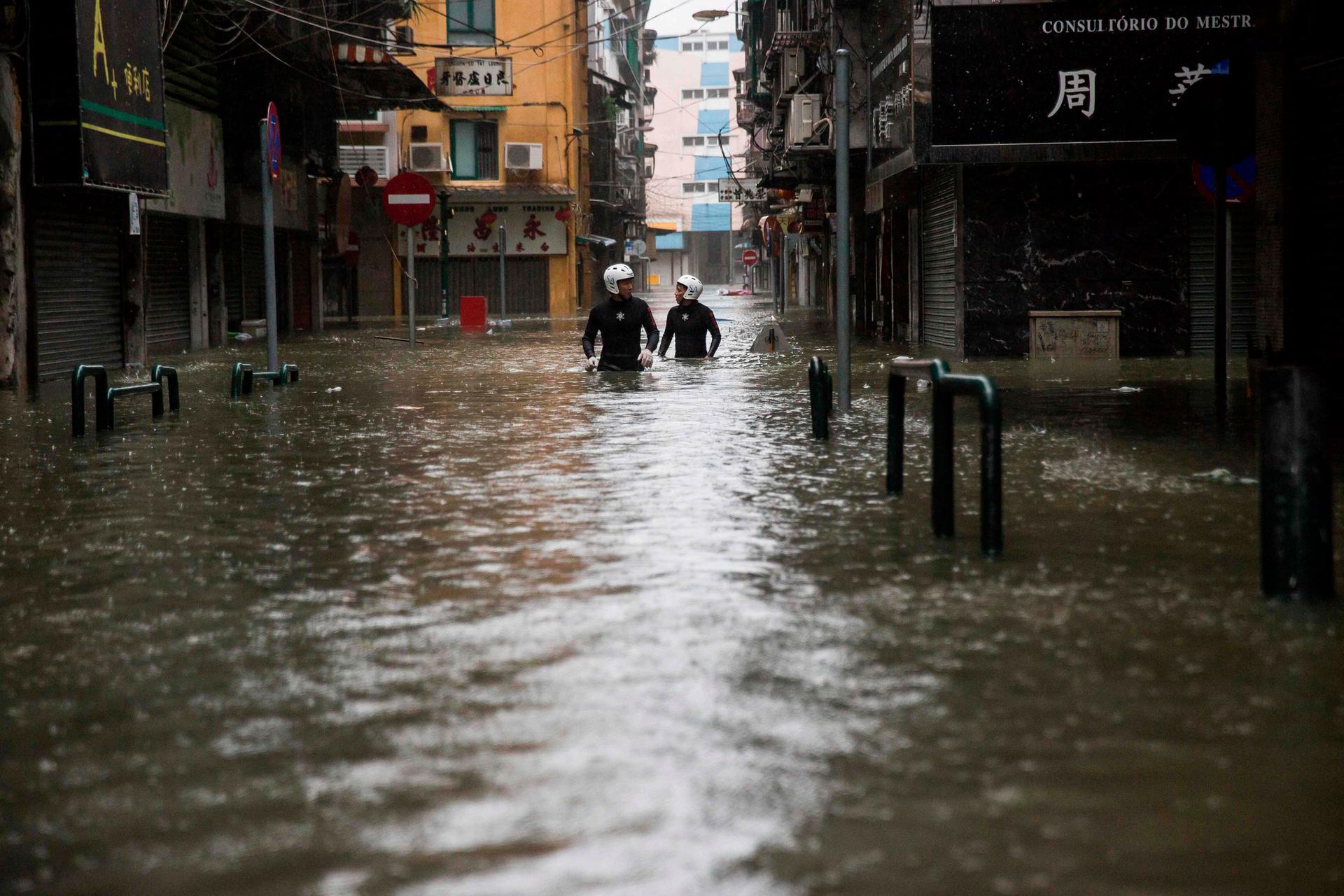 Rescue workers make their way through floodwaters during a rescue operation in Macau. AFP