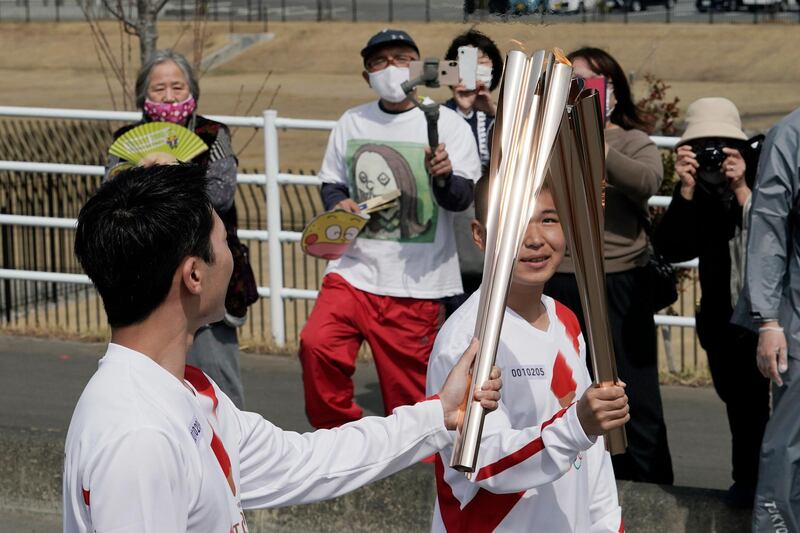 Local torchbearers pass the Olympic flame. AP