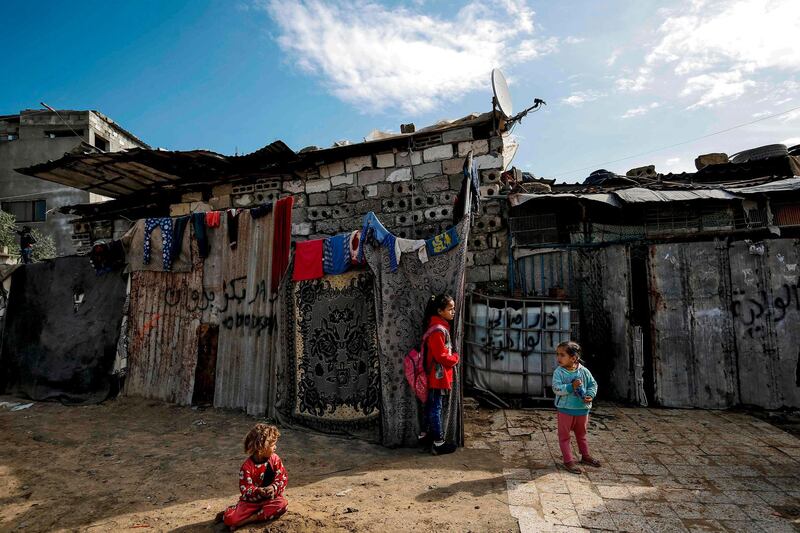 A Palestinian girl stands next to the door of her home upon returning from school in Gaza City.  AFP