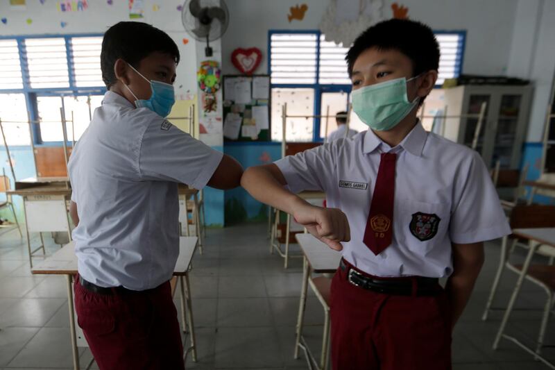 Students practice Covid-19 greetings during a health protocol class in Banda Aceh, Indonesia. EPA