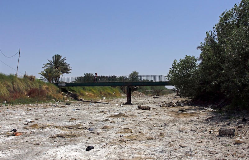 This picture shows an empty riverbed in Umm Abbasiyat, some 60 kilometers east of Najaf, on July 5, 2018. - Beyond this year's dramatic lack of rain, experts say a central reason for Iraq's creeping drought is the regional sharing of its water resources. Neighbouring Turkey and Iran in recent years have both rerouted cross-border water sources they share with Iraq. (Photo by Haidar HAMDANI / AFP)