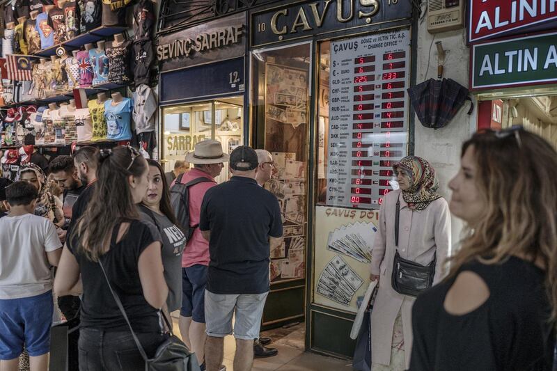 Pedestrians gather near a gold and currency exchange store at the Grand Bazaar in Istanbul, Turkey, on Friday, Aug. 17, 2018. Turkish President Recep Tayyip Erdogan argued citizens should buy gold, then he said sell. Add dramatic swings in the lira, and the country’s traders are now enthusiastically doing both. Photographer: Ismail Ferdous/Bloomberg