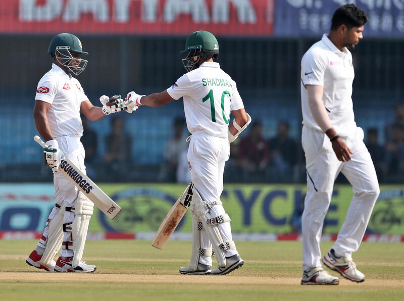 Bangladesh's Imrul Kayes, left, touch gloves with batting partner Shadman Islam after hitting a boundary. AP