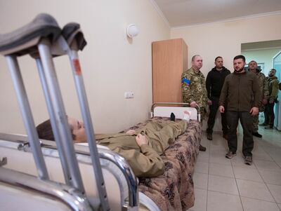 Ukraine's President Volodymyr Zelenskiy speaks to an injured Ukrainian service member, as Russia's attack on Ukraine continues, during a visit to a military hospital in Kyiv, Ukraine April 3, 2022.  Reuters
