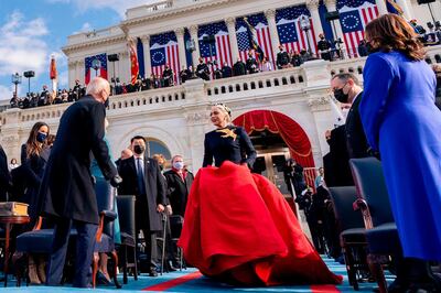 US singer Lady Gaga (C) arrives to perform the National Anthem as President-elect Joe Biden (L) and Vice President-elect Kamala Harris (R) watch during the 59th Presidential Inauguration on January 20, 2021, at the US Capitol in Washington, DC.  / AFP / POOL / Andrew Harnik
