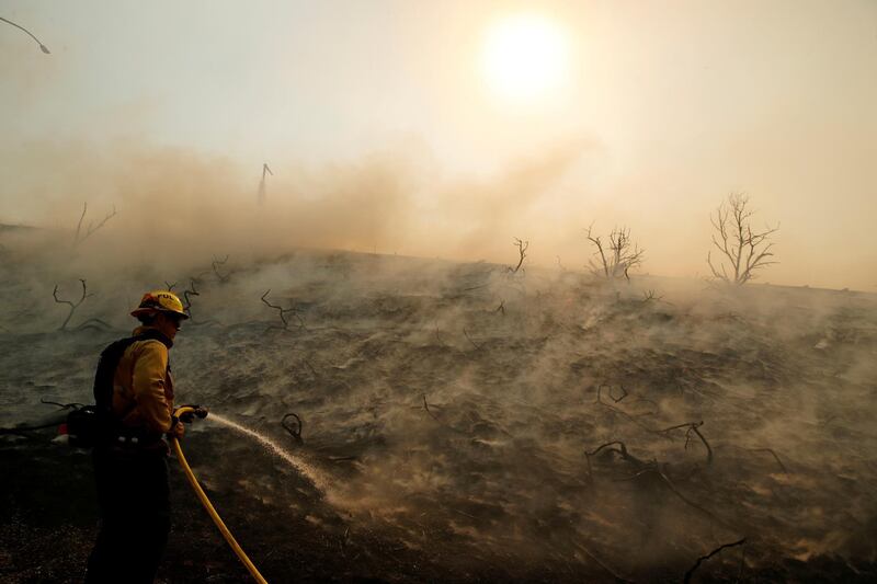 A firefighter uses a hose as the Silverado Fire approaches, near Irvine, California, U.S. October 26, 2020. REUTERS