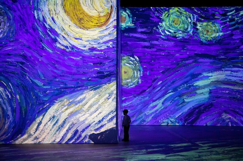 A boy is silhouetted as he watches a preview of the 'Imagine Van Gogh' immersive exhibition in Vancouver, British Columbia. Canadian Press via AP