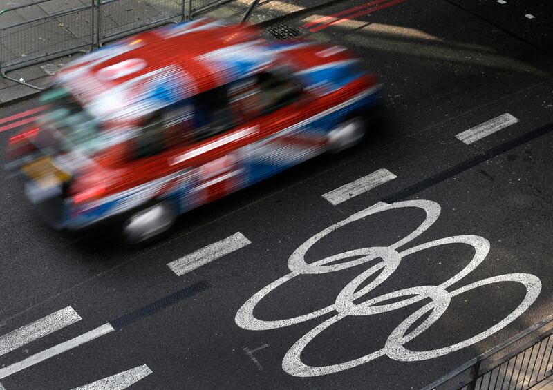 A taxi cab passes an Olympic lane a central London Wednesday, July 25, 2012. The city will host the 2012 London Olympics with opening ceremonies scheduled for Friday, July 27. (AP Photo/Charlie Riedel)