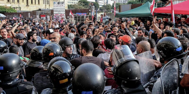 epa07949730 Riot police tries to separate Hezbollah supporters shouting pro-Hezbollah slogans and anti-government protesters, during a ninth day of anti-government protests in Beirut, Lebanon, 25 October 2019. Thousands took to the streets during a second weeek of protests against proposals of tax hikes and state corruption, and calling for the resignation of the government.  EPA/NABIL MOUNZER