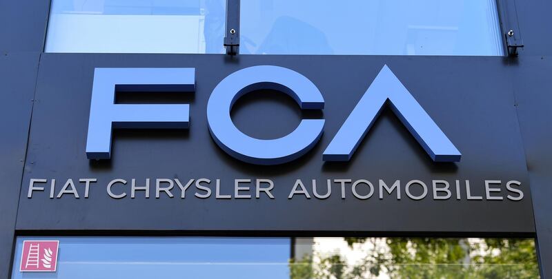 A picture taken on July 22, 2020 shows the logo of carmaker "FCA Fiat Chrysler Automobiles" on the facade of the group's offices in Frankfurt am Main, western Germany. Investigators in Germany, Switzerland and Italy are searching several sites over suspicion that vehicles built by Fiat Chrysler and Iveco groups may have been fitted with illegal defeat devices, as the "dieselgate" emissions scandal widened. / AFP / DPA / Arne Dedert
