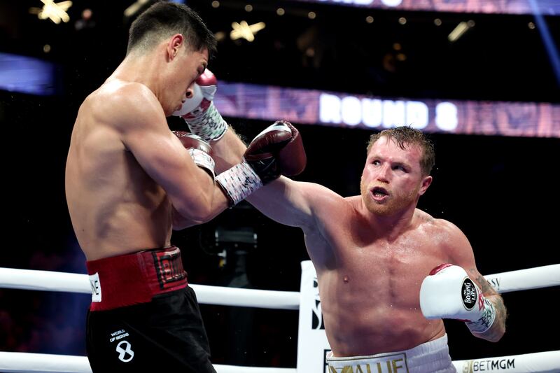 Canelo Alvarez exchanges punches with Dmitry Bivol during their WBA light heavyweight title fight at T-Mobile Arena.
