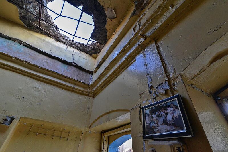 A family picture hangs on the wall of a heavily damaged house in the Old City of Mosul. AFP