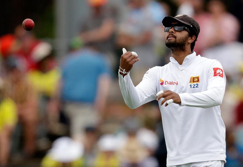 Sri Lanka's Dinesh Chandimal passes the ball to his bowler during their cricket test match against Australia in Canberra, Friday, Feb. 1, 2019. (AP Photo/Rick Rycroft)