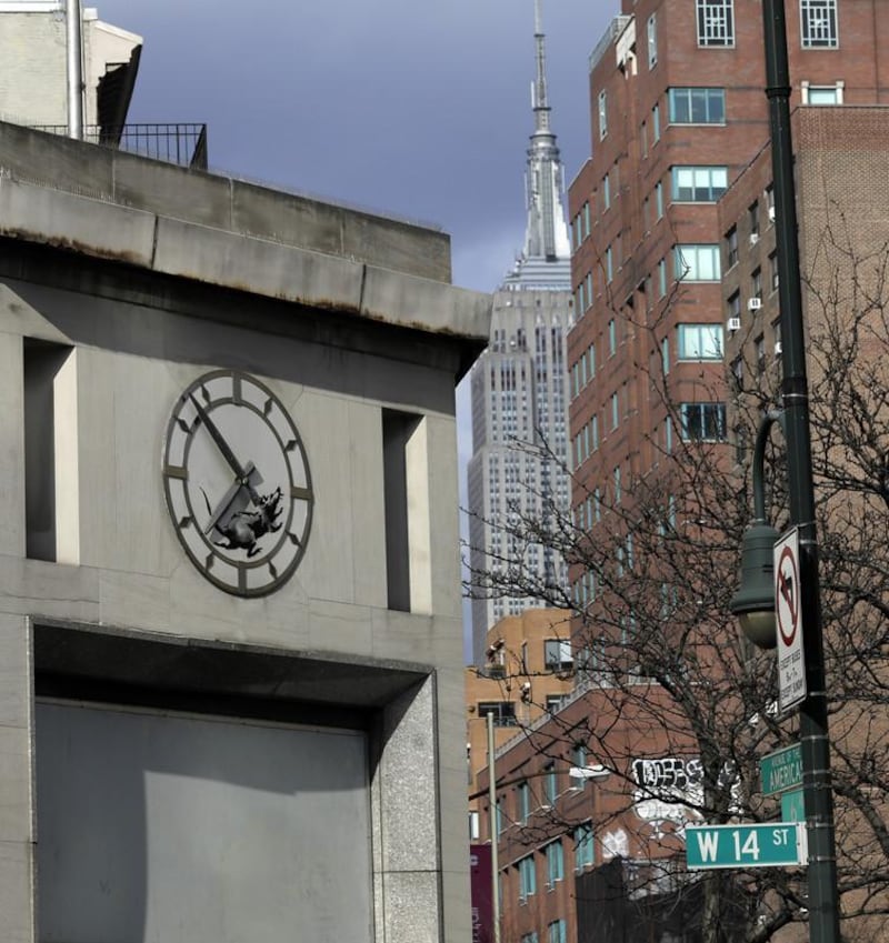 epa06606938 A new street art work by Banksy, the anonymous British street artist is of a rat In the inner portion of a clock above a closed former bank building on 14th Street and 6th Avenue in New York City, USA, 15 March 2018.  EPA-EFE/JASON SZENES