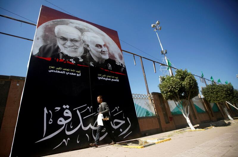 A man passes next to a billboard with posters of Iranian Major-General Qassem Suleimani, head of the Quds Force, and Iraqi militia commander Abu Mahdi al-Muhandis, who were killed in an air strike at Baghdad airport, in Sanaa. Reuters