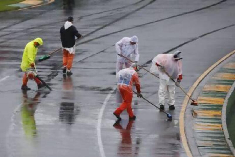 Marshals remove excess water on the track before the qualifying session of the Australian F1 Grand Prix at the Albert Park circuit. Daniel Munoz / Reuters