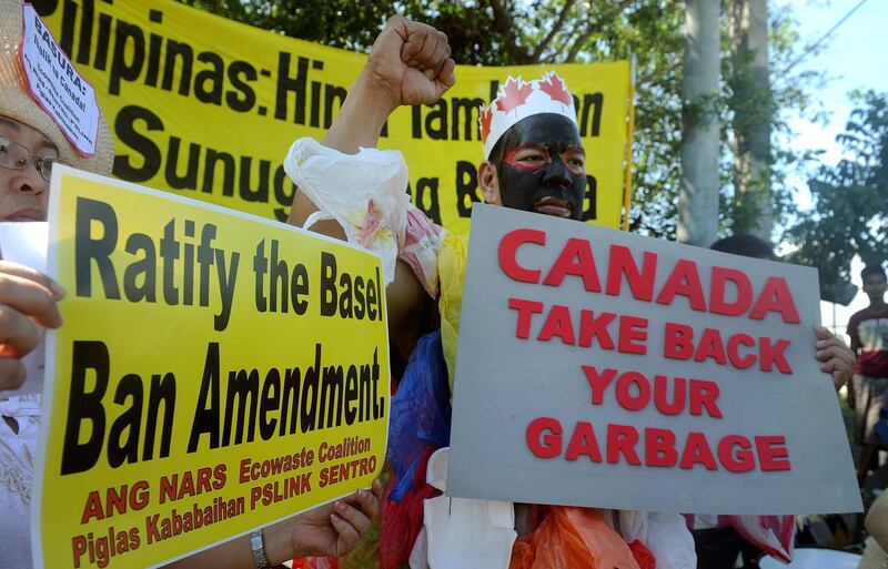 This file photo taken on September 9, 2015, shows environmental activists rallying outside the Philippine Senate in Manila to demand that scores of containers filled with household rubbish be shipped back to Canada.  The Philippines recalled its ambassador to Canada after Ottawa missed Manila's deadline for it to take back tonnes of trash illegally shipped to the nation, its foreign minister said on May 16, 2019. - 
 / AFP / JAY DIRECTO

