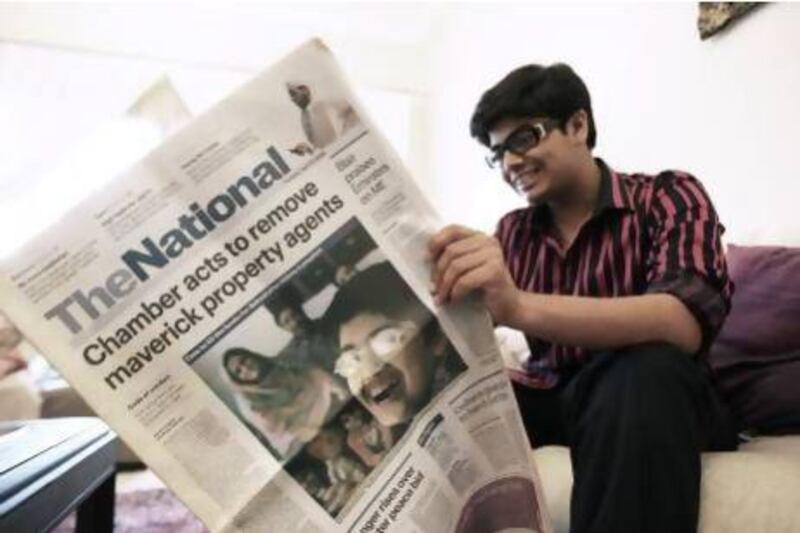 Nabeel Kamran, 17, pages through the first copy of The National newspaper. He was 12 when his story about a successful kidney transplant was published on page one. Pawan Singh / The National