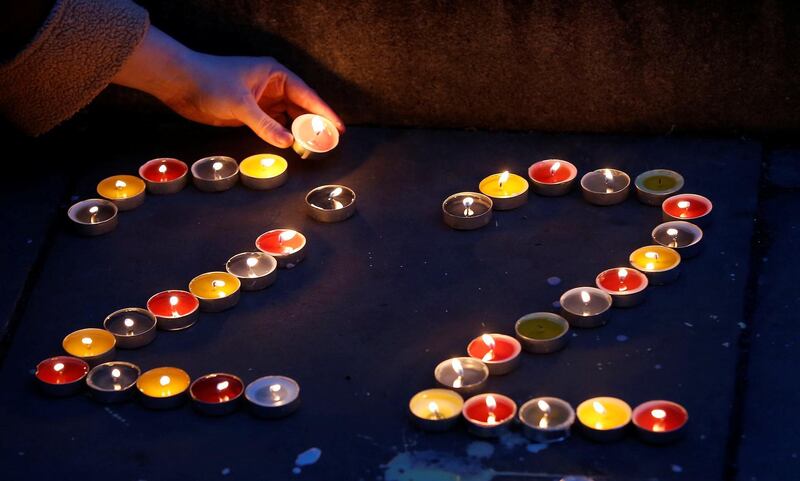 A woman places candles for each of the dead as a tribute in St Anne's Square. REUTERS/Andrew Yates