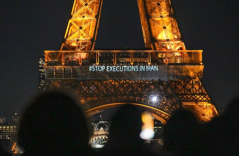 The Eiffel Tower lits the night with the a slogans "Stop Executions in Iran" and "Woman, Life, Freedom" in support for the protests across Iran in Paris, Monday, January 16, 2023. AP