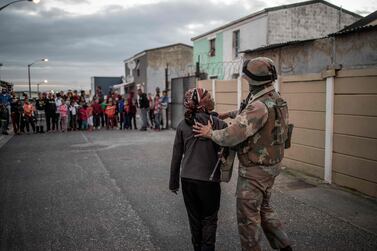 South African National Defence Forces soldier directs a woman during a joint police operation in Cape Flats. AFP