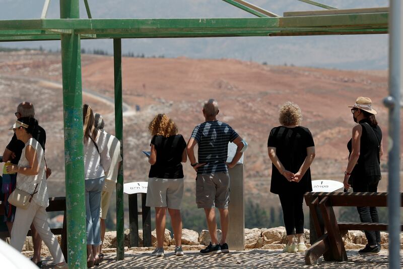 Israeli tourists look out over the Israel-Lebanon border, near the village of Metula.