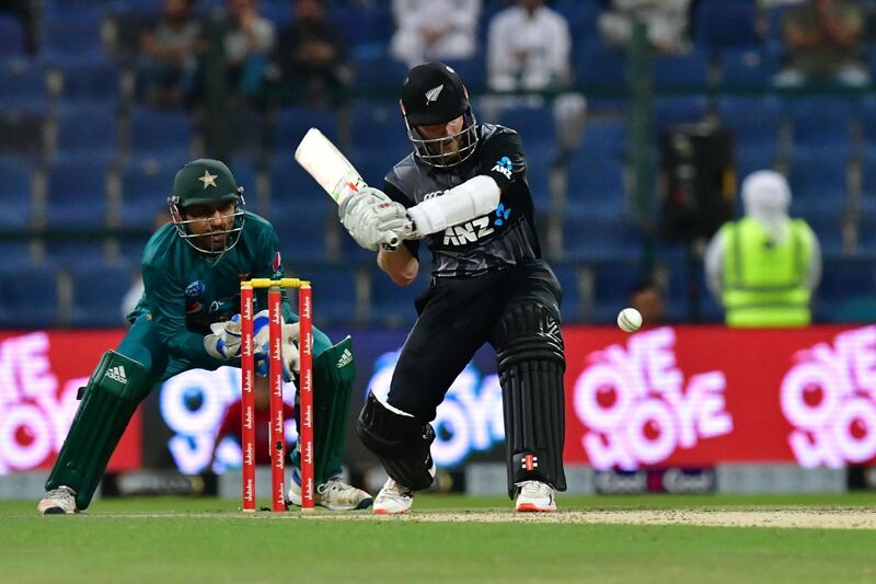 New Zealand cricketer Kane Williamson (C) is watched by Pakistan's wicketkeeper Sarfraz Ahmed as he plays a shot, during the first T20 cricket match between Pakistan and New Zealand at the Abu Dhabi Cricket Stadium in Abu Dhabi on October 31, 2018.  / AFP / GIUSEPPE CACACE
