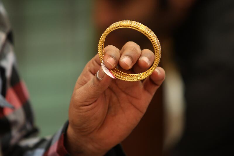 DUBAI , UNITED ARAB EMIRATES Ð Nov 11 : Salesman showing gold bangle to one of the customer on Dhanteras at one of the jewelry shop in Meena Bazar in Bur Dubai. Dhanteras is the first day of five days Diwali festival as celebrated in parts of North India. ( Pawan Singh / The National ) For News. Story by Preeti