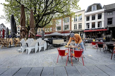 epa09150298 The terrace of a cafe is being made coronavirus proof by employees in Utrecht, The Netherlands, 21 April 2021. The Dutch cabinet has decided that the terraces for outdoor services can reopened to a maximum of 50 customers.  EPA/ROBIN VAN LONKHUIJSEN