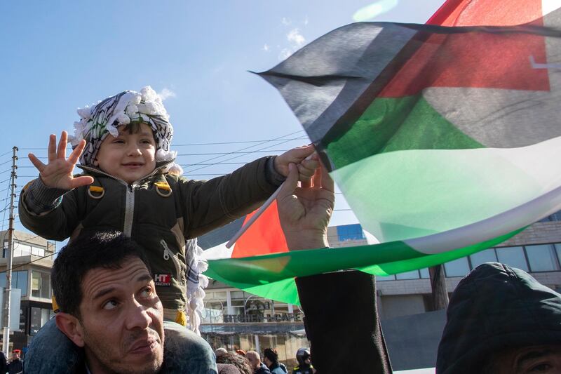 epa08181960 A young protester wearing the Palestinian Keffiyeh waves the Palestinian flag, during a protest against the so-called 'Deal of the Century', next to the US Embassy in Amman, Jordan, 31 January 2020. The Middle East Peace Plan announced by the US President Trump and rejected by the Palestinians aims to solve the conflict between Israelis and Palestinians.  EPA/ANDRE PAIN